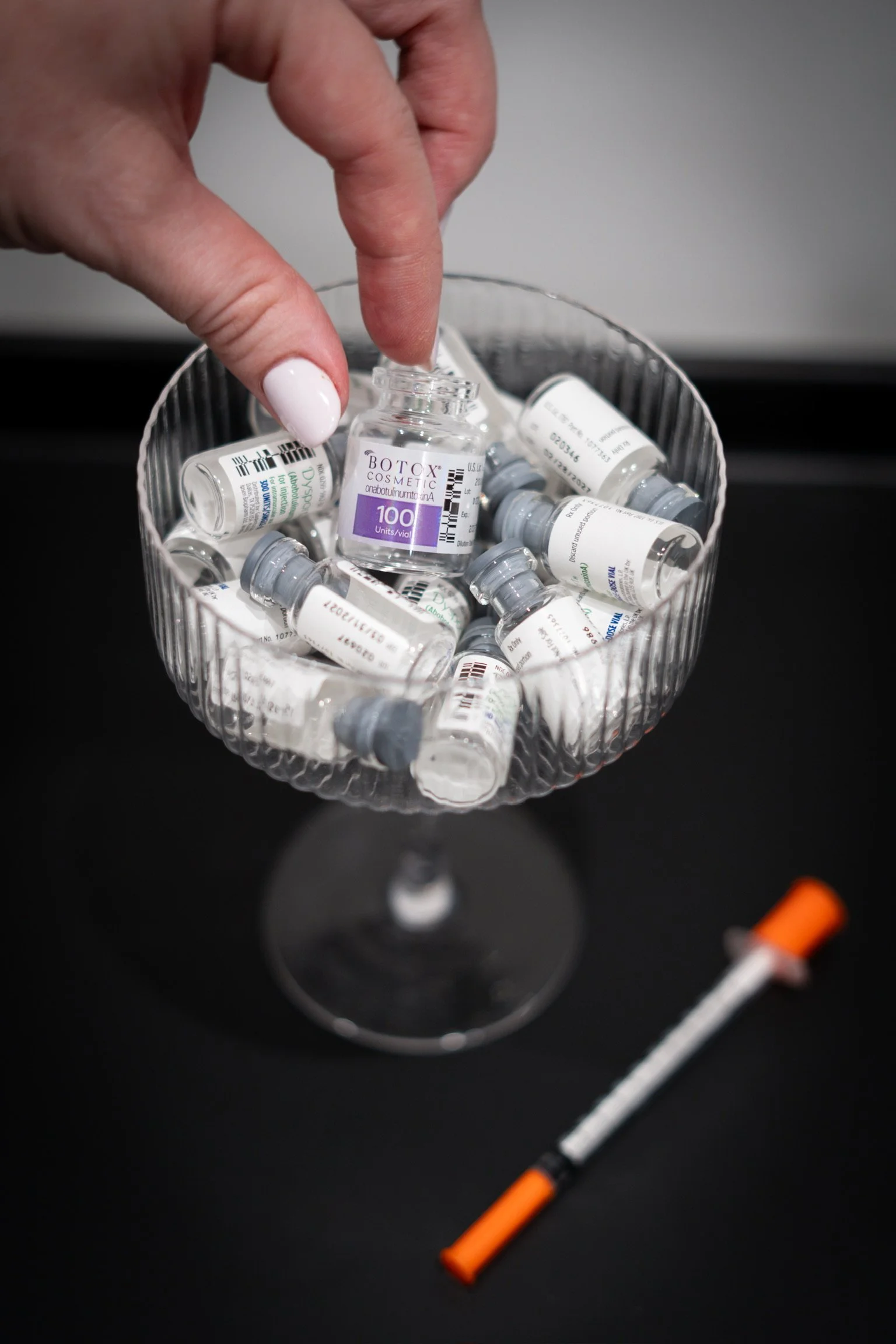 Botox Cosmetic and Dysport vials presented in a coupe glass at The Aesthetic Ranch medical spa in Fort Lauderdale, FL.