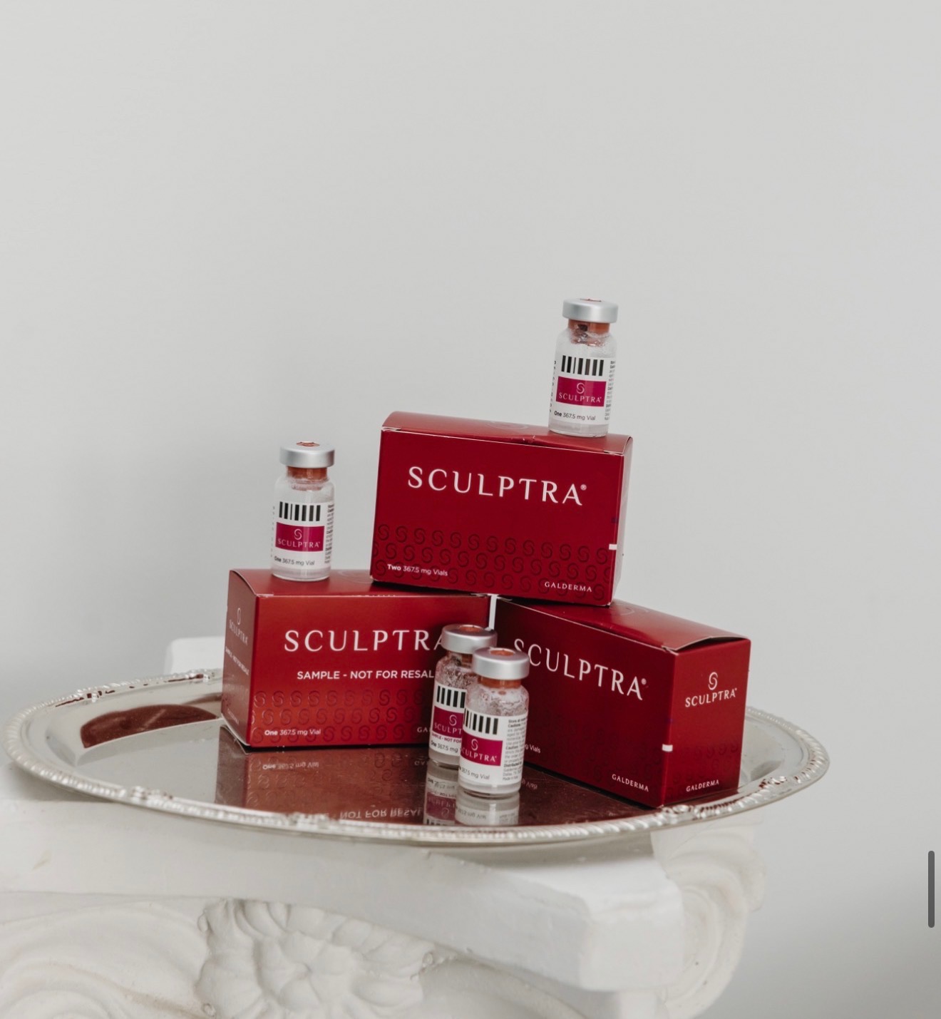 Sculptra Aesthetic vials and Galderma boxes presented on a silver tray at The Aesthetic Ranch medical spa in downtown Fort Lauderdale, FL, the poly-L-lactic acid collagen biostimulator used in bio-regenerative facial treatments.