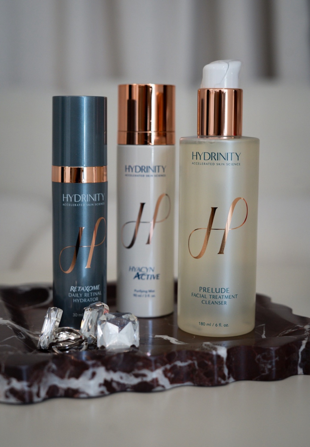 Hydrinity RetaXome, Hyacyn Active, and Prelude cleanser on a marble tray at The Aesthetic Ranch in Fort Lauderdale, FL.